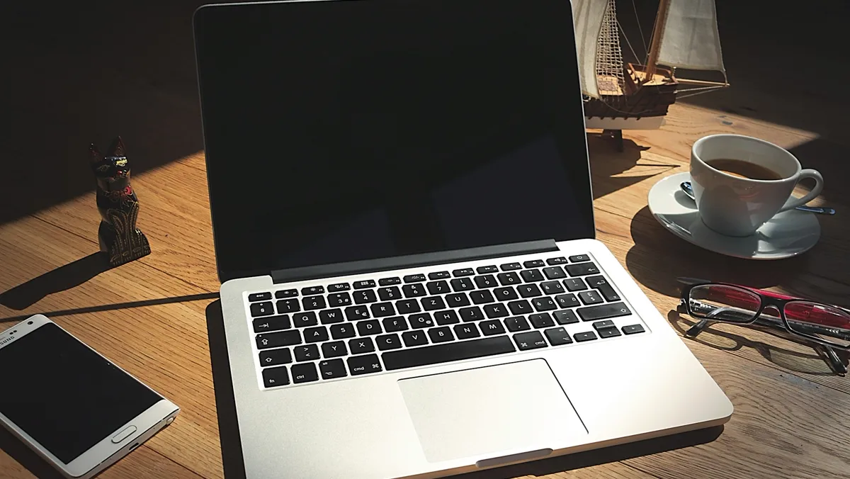 A laptop and notebook on a wooden desk