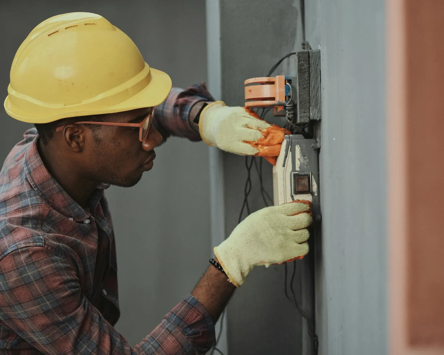 An electrician working inside an open electrical panel